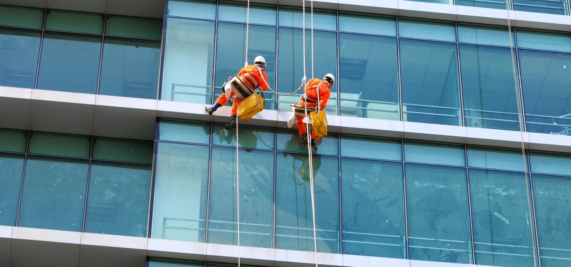 ludzie myjący okna na zewnątrz budynku